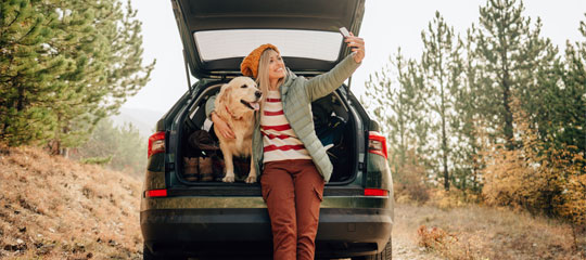 Woman with dog on tailgate.