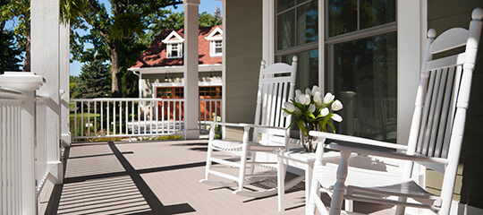 Rocking chairs on a porch of a house.