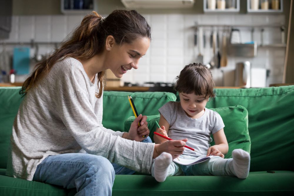 Babysitter on couch with child.