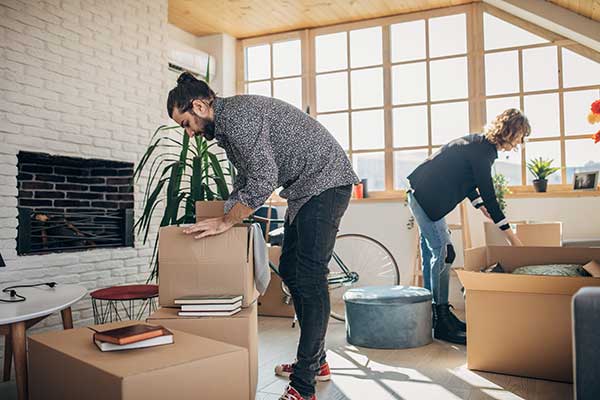 Young couple unpacking boxes in an apartment.