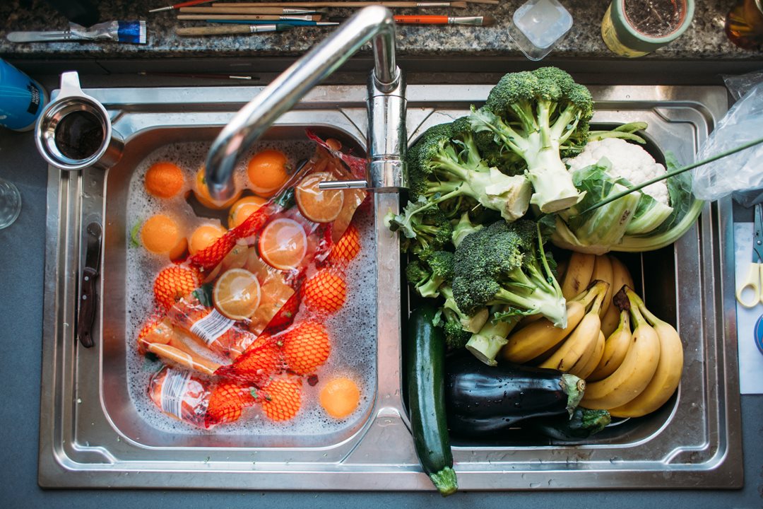 Fruits and vegetables in a sink.