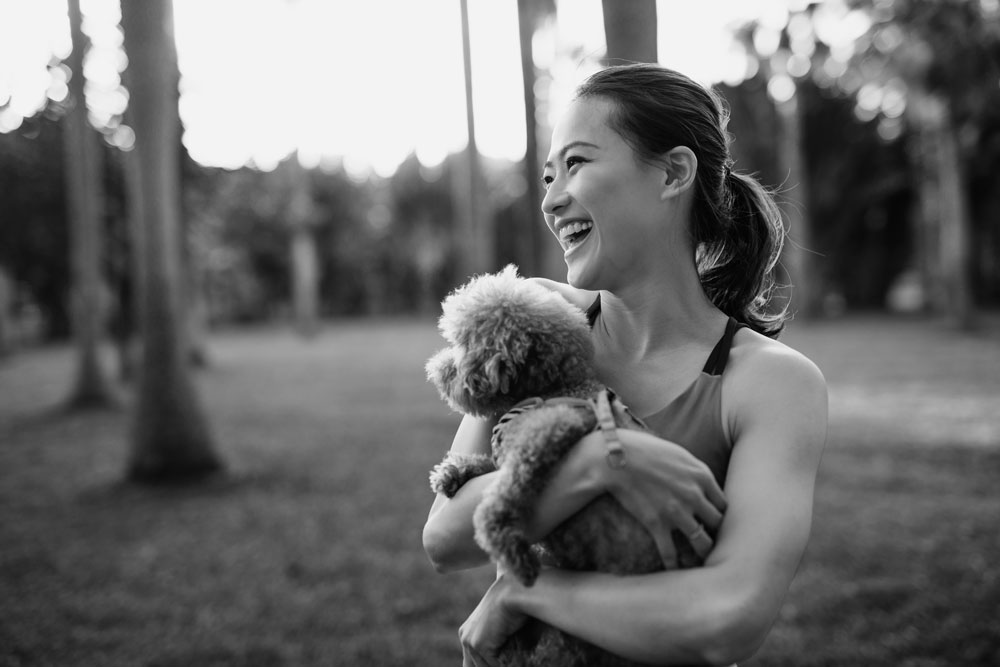 Woman outside holding puppy.